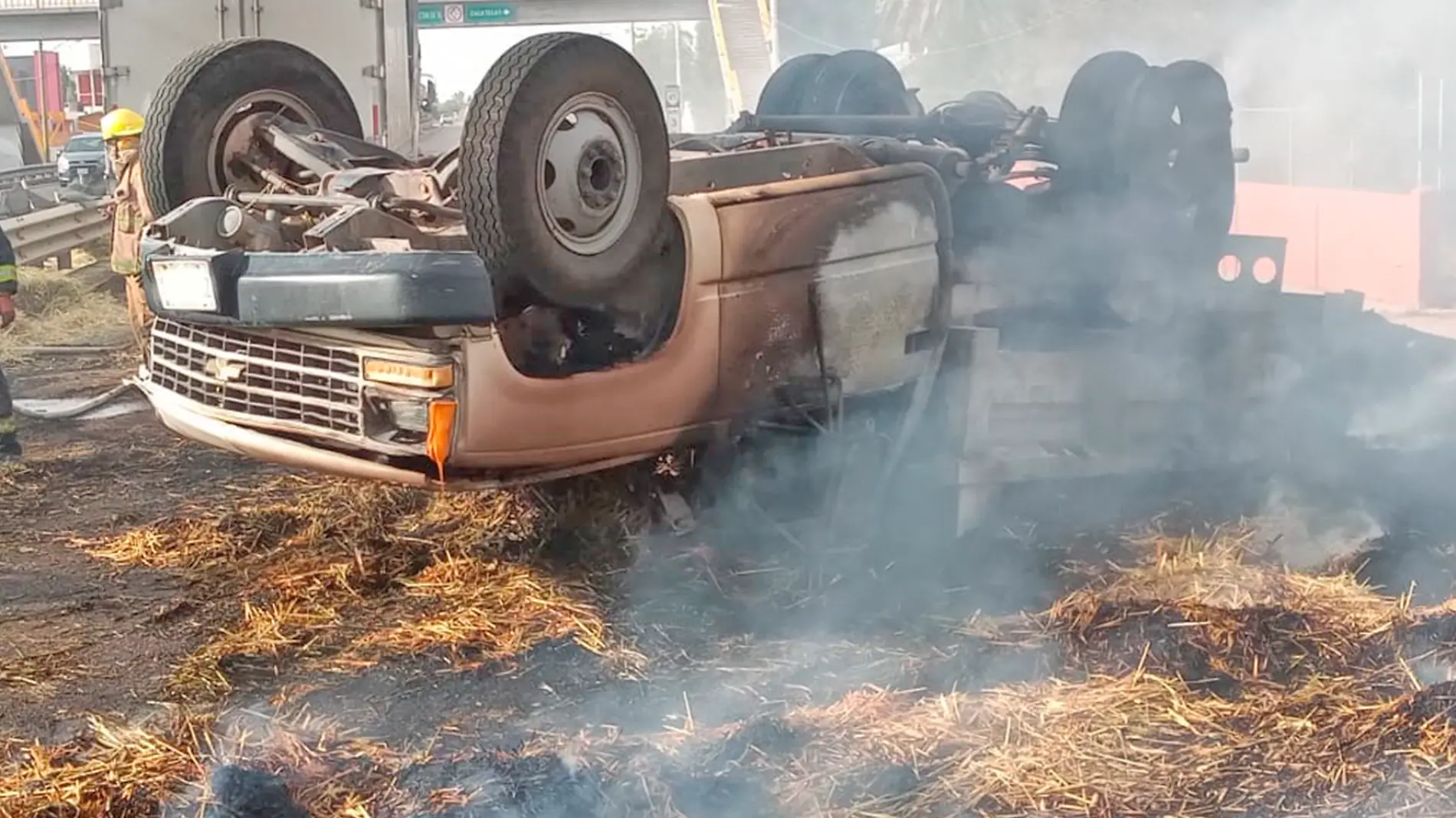 camioneta volcada e incendiada